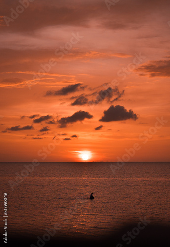 Persona pescando en el mar durante hermoso atardecer