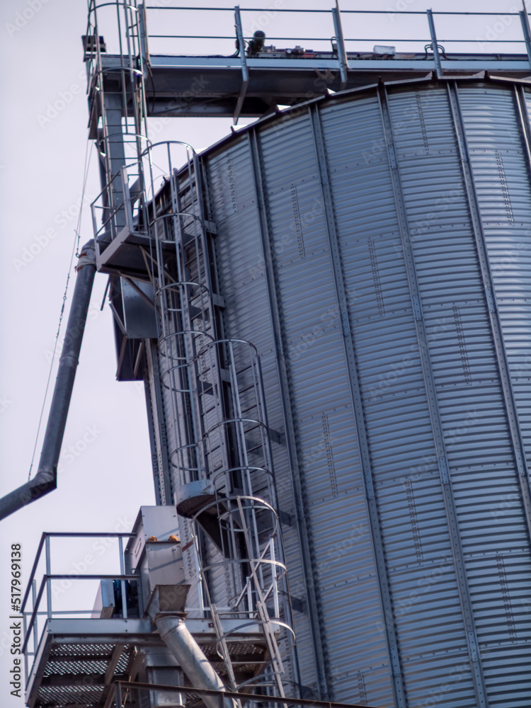 Modern elevator for grain storage. A large plant for the storage and processing of grain crops, view of the granary on a cloudy day. Agro manufacturing plant for processing and drying