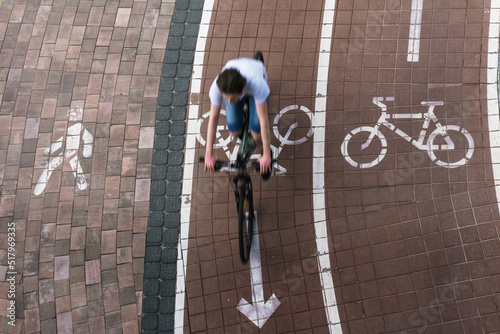 Person rides on bike at cycleway lane top view. Transportation safety concept.
