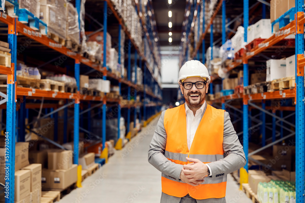 Portrait of a happy businessman posing in storage.