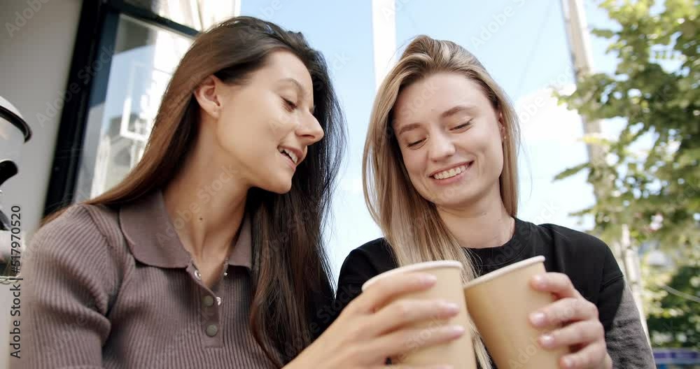 Two girls rest and serve coffee and tea outside at morning work day, converse and smile outside near a terrace, lifestyle coffee time. Two girls rest and serve coffee and tea outside at morning work day, converse and smile outside near a terrace, lifestyle coffee time.