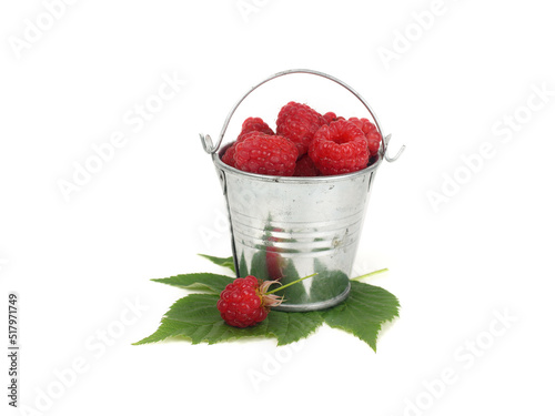 Fresh raspberry and green leaf. Berries in a small bucket. Photo on a white background.