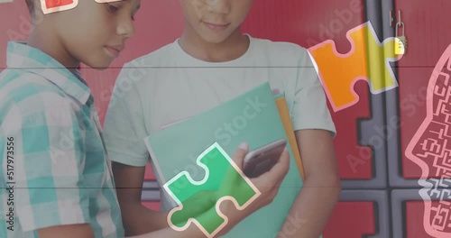 Jigsaw puzzle and human head icon against two diverse boys using smartphone at school photo