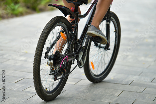 selective focus. cyclist on a bicycle leg and wheel close-up. Back view. A walk on the bike. the female rides a bicycle. Cyclist pedaling on a bicycle. High quality photo