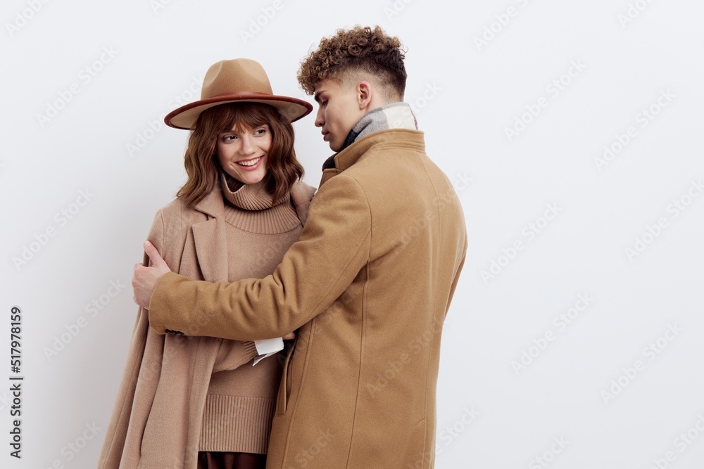a sweet, beautiful, loving couple stands on a white background in stylish autumn clothes, a woman has a hat on her head, and she gently snuggles up to a man a sweet, beautiful, loving couple stands on a white background in stylish autumn clothes, a woman has a hat on her head, and she gently snuggles up to a man