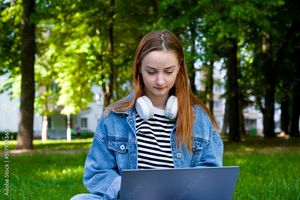 Front view on female using laptop for work or education in the parl.Remote edication or work concept Front view on female using laptop for work or education in the parl.Remote edication or work concept