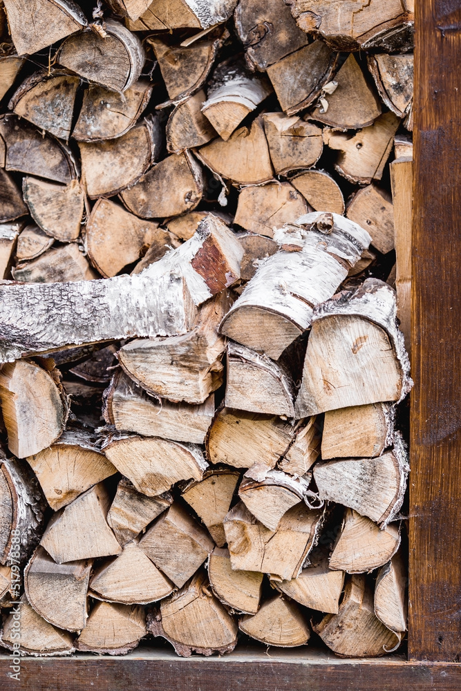 Fototapeta premium Heating season without gas. It's warm in the house. A stack of firewood for heating the house. The trees were cut down and split into firewood for use as fuel for fireplaces and stoves.