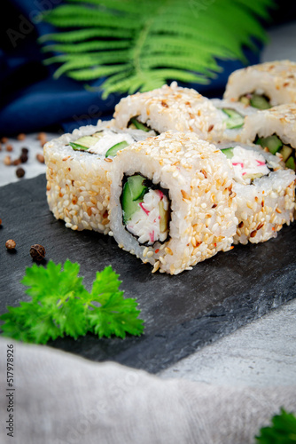 Sushi California rolls with sesame and avocado, crab sauce and cucumber. Traditional Japanese cuisine