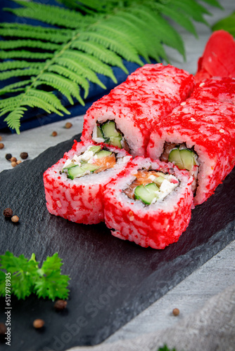 Sushi California rolls with salmon, crab sauce, avocado, cucumber and masago. Traditional Japanese Cuisine
