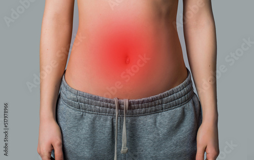 woman's stomach with redness on gray background. stomach problems concept photo