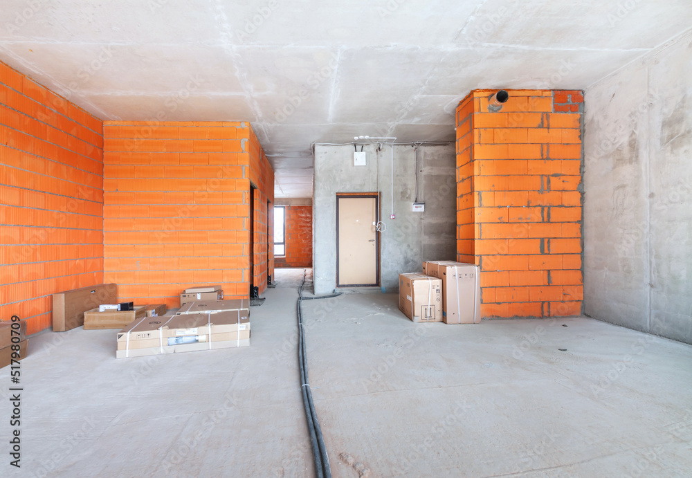 The unfinished room in a residential building under construction interior with red brick bare