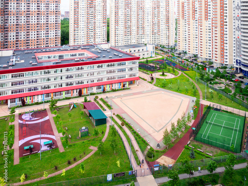 Public school building. Exterior view of school building with playground mixed-use urban multi-family residential district area development. Back to school concept.