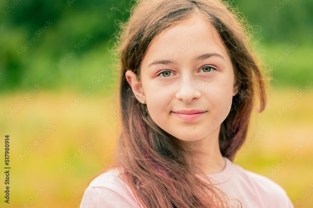 Teenage girl with blond hair on the background of nature on a hot day. Girl on a green background. Teenage girl with blond hair on the background of nature on a hot day. Girl on a green background.