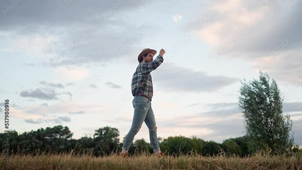 Caucasian man agriculturist go home after inspects a field of small wheat Caucasian man agriculturist go home after inspects a field of small wheat