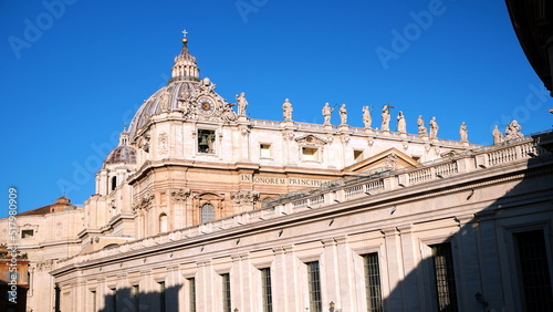 dome of San Pietro and building with characteristic round clock on top, in the morning sun photo