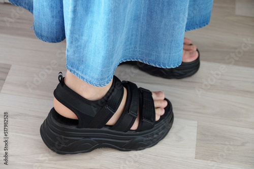 female legs in black bulky sandals close-up