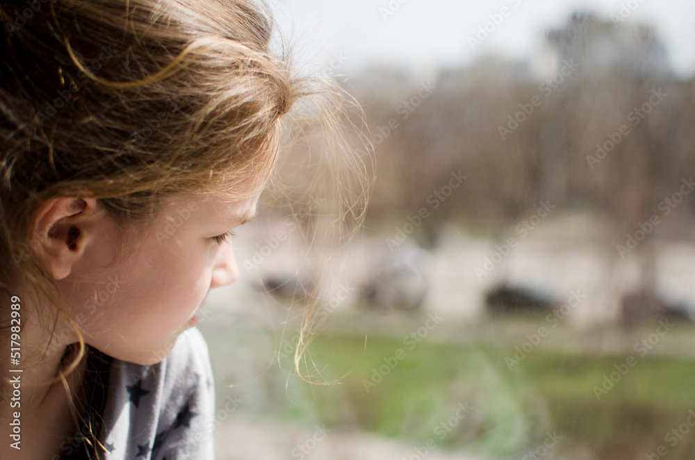 The child looks out the window. blurred The child looks out the window. blurred