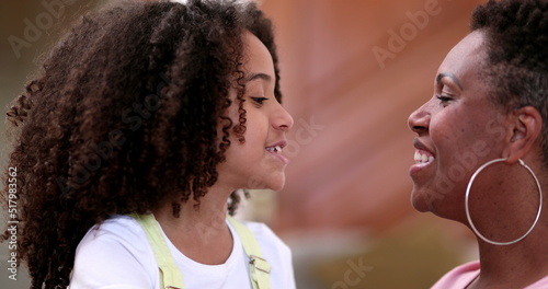 Mixed race daughter and mother interaction, African mom and child smiling