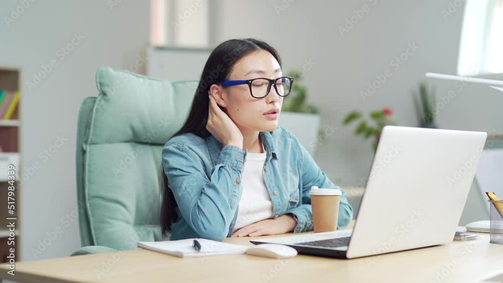 young asian girl student studying online remotely using video call remote lessons sitting at desk at home or classroom. indoor. Woman writes in notebook takes notes while looking at laptop screen young asian girl student studying online remotely using video call remote lessons sitting at desk at home or classroom. indoor. Woman writes in notebook takes notes while looking at laptop screen