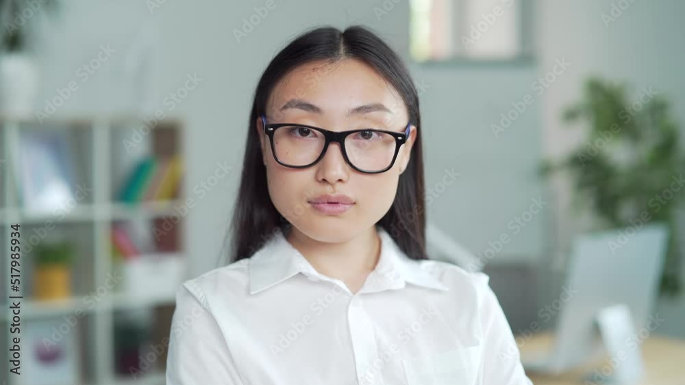 Closeup portrait asian business lady in formal shirt, glasses looking at camera. confident proud young woman businesswoman employee entrepreneur at workplace in modern office. Indoor. head shot. Asia Closeup portrait asian business lady in formal shirt, glasses looking at camera. confident proud young woman businesswoman employee entrepreneur at workplace in modern office. Indoor. head shot. Asia