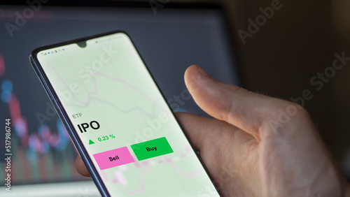 An investor's analizing the ipo etf fund on a screen. A phone shows the prices of IPO ETF to invest in initial public offering photo