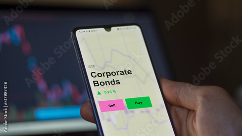 An investor's analizing the corporate bonds etf fund on a screen. A phone shows the prices of an ETF