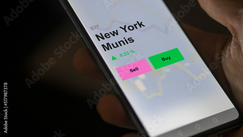 An investor's analizing the new york munis etf fund on a screen. A phone shows the prices of New York Munis photo