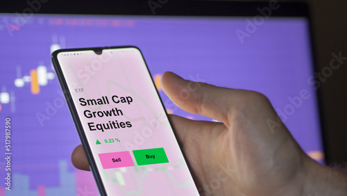 An investor's analizing the small cap growth equities etf fund on a screen. A phone shows the prices of smallCap equity ETF.