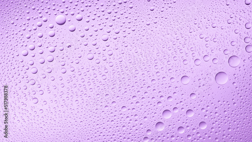 Water drops on the wet glass surface on purple background | Background for skin care moisturizing products