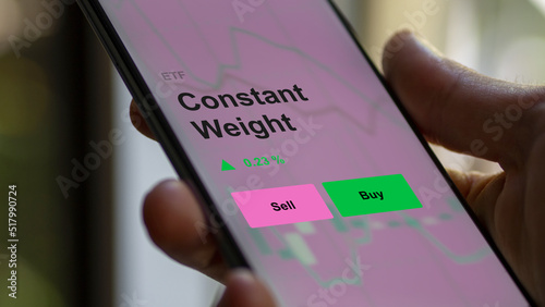 An investor's analyzing the constant weight etf fund on a screen. A phone shows the prices of equal weighting ETFs. photo