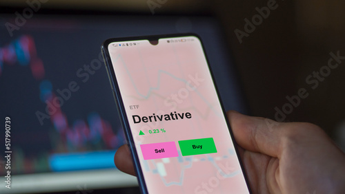 An investor's analizing the derivative etf fund on a screen. A phone shows the prices of Derivative photo