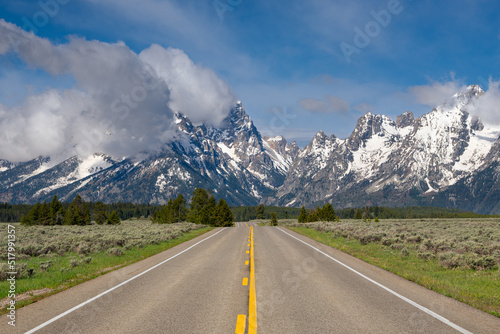 Highway in Grand Teton National Park under show-capped mountain peaks