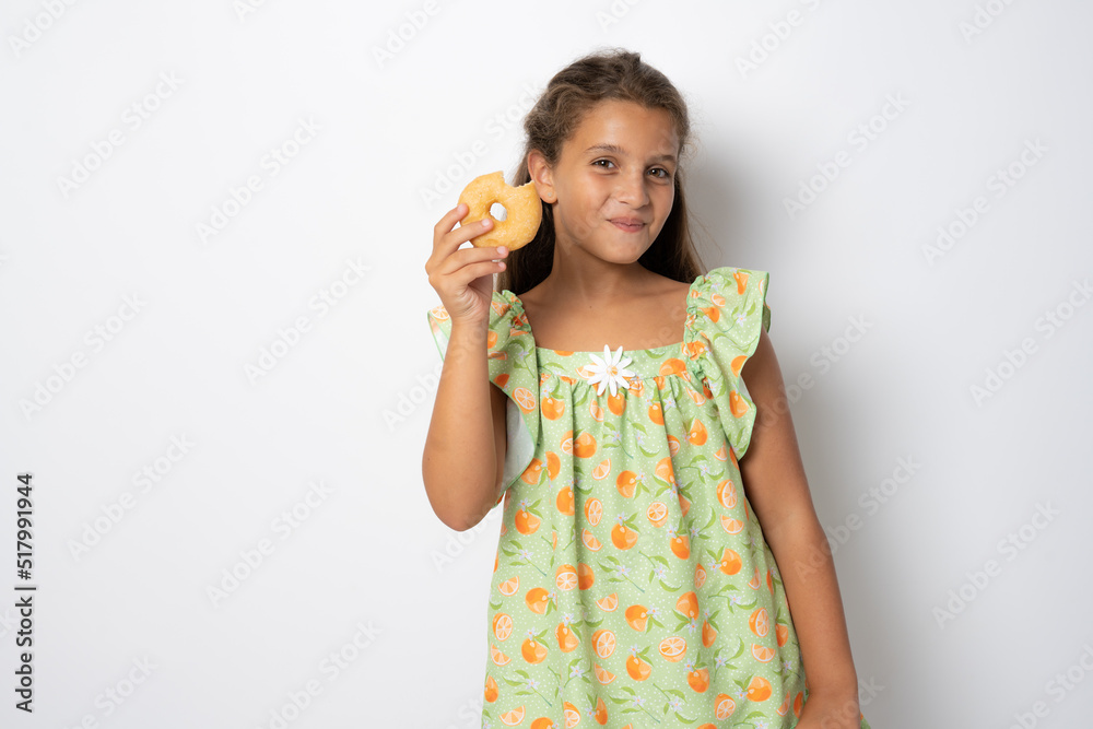 Close up portrait of a satisfied pretty brunette girl eating donuts isolated over white background Close up portrait of a satisfied pretty brunette girl eating donuts isolated over white background