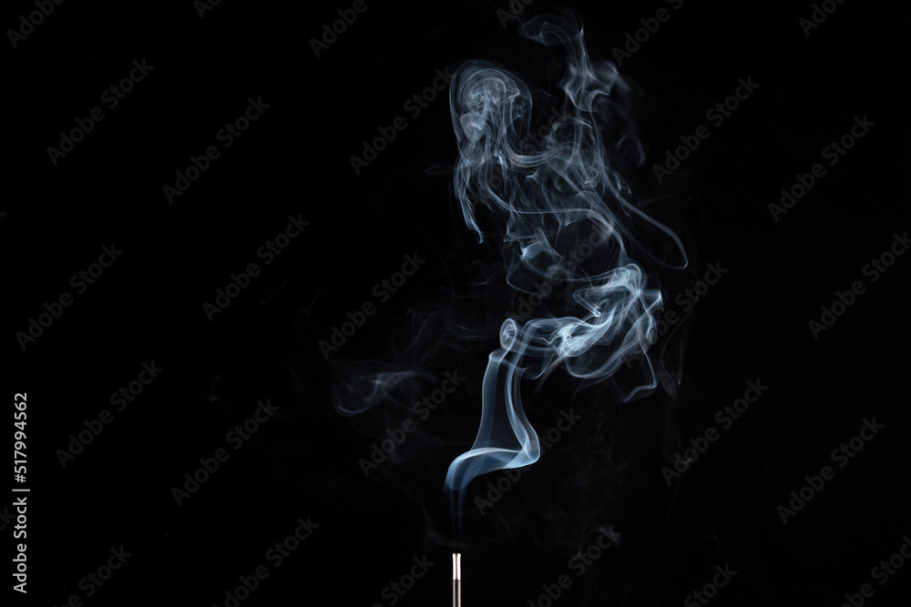 incense stick with smoke against black background incense stick with smoke against black background