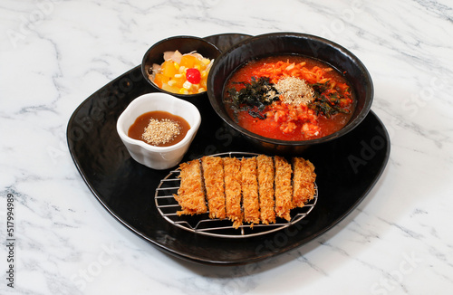 Korean Kimchi Noodle and pork cutlet set on bright background.