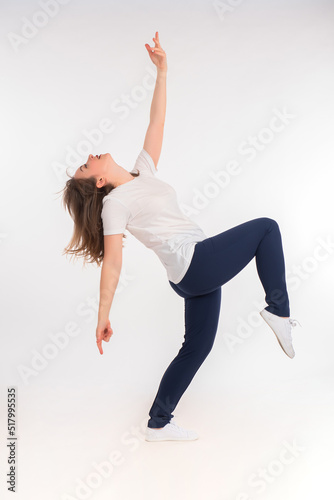 A happy woman stands on one...