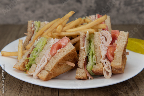 Loaded turkey club sandwich, cut into 4 wedges and covered in french fries will ensure that the belly will be full