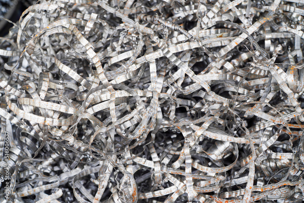 Steel scrap materials recycling. Aluminum chip waste after machining metal parts on a cnc lathe. Closeup twisted spiral steel shavings. Small roughness sharpness, Steel scrap materials recycling. Aluminum chip waste after machining metal parts on a cnc lathe. Closeup twisted spiral steel shavings. Small roughness sharpness,
