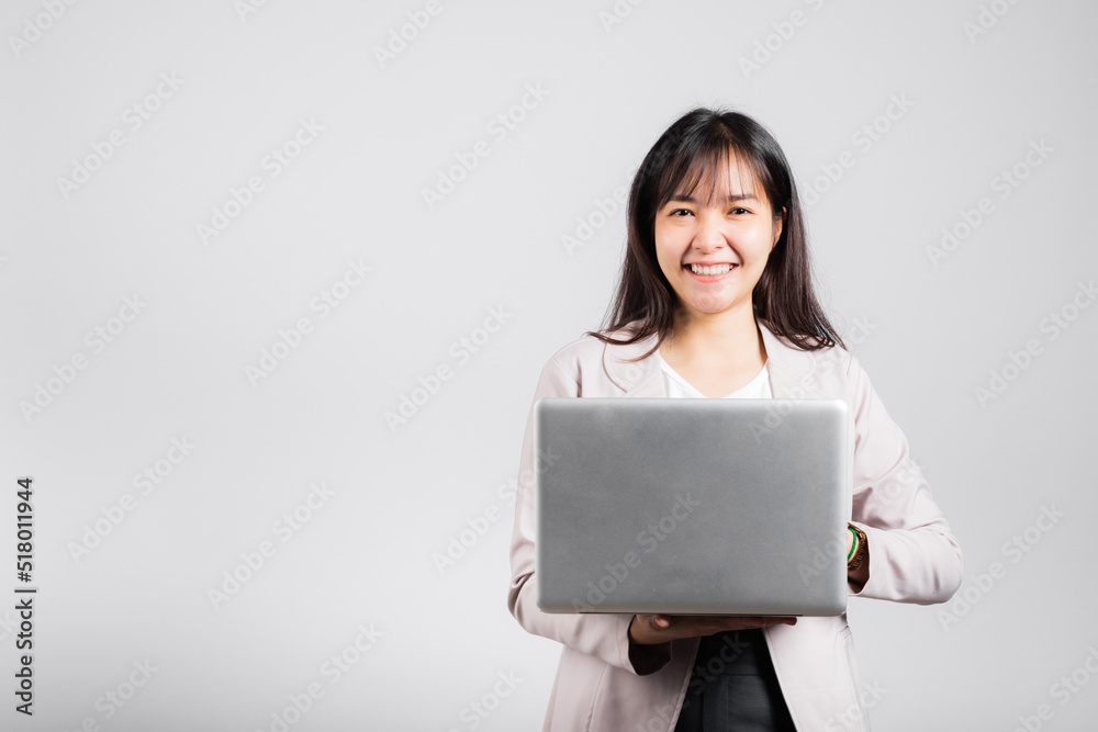 Woman smiling confident smiling holding using laptop computer and typing keyboard for online sending email or chat, Portrait excited happy Asian young female studio shot isolated on white background Woman smiling confident smiling holding using laptop computer and typing keyboard for online sending email or chat, Portrait excited happy Asian young female studio shot isolated on white background