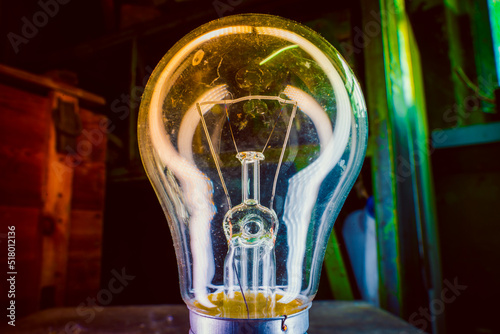 Old incandescent light bulb close-up on colorful lighting photo