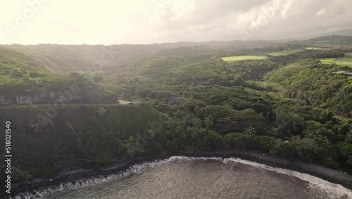 A backward drifting aerial provides a view of Honokohau Bay and the splendor of the islands. Tropical rain and mist fill the distance as one would expect in this chain of mountainous microclimates