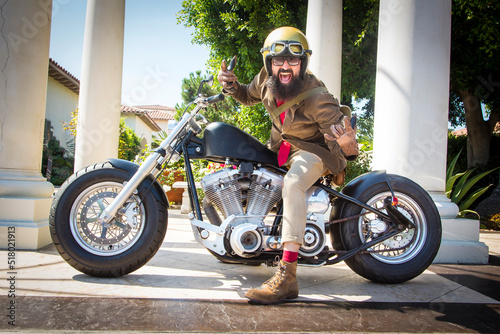 Obraz na płótnie A man with a beard on a motorcycle wearing a gold helmet