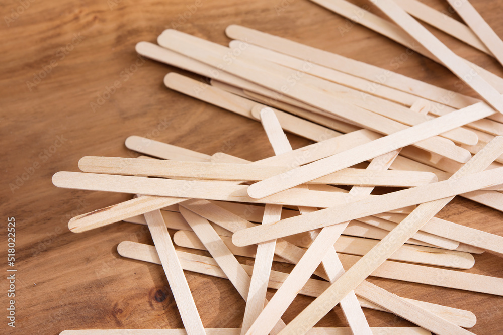 Educative craft. Popsicle sticks on wooden desk. Shallow depth of field.