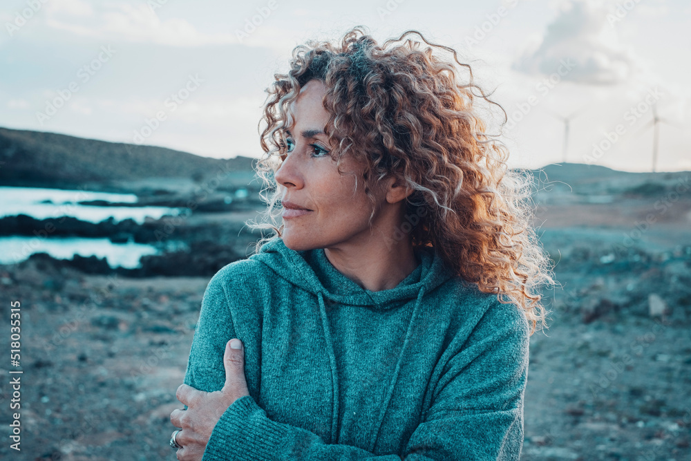 Concept of young woman and emotions. Inner balanced portrait of female enjoying freedom and sensations outdoor. Travel and wanderlust lifestyle people. Beautiul lady with curly long hair smiling - obrazy, fototapety, plakaty 