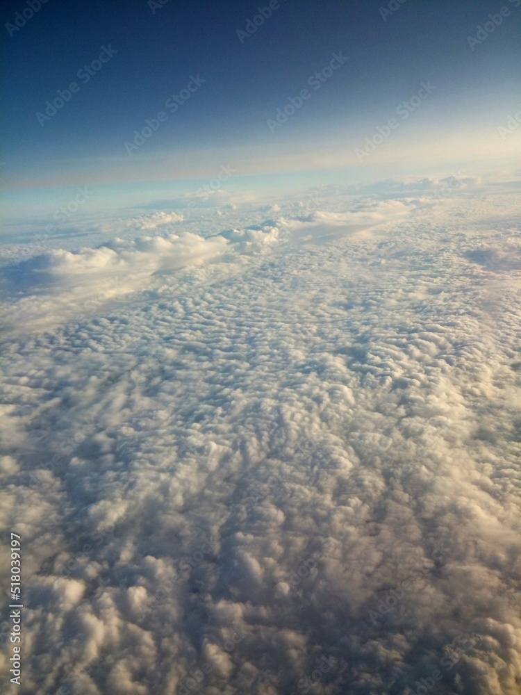 Naklejka premium high above white fluffy clouds blue sky