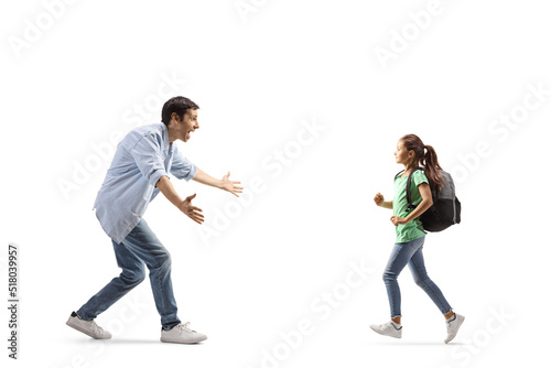Father and schoolgirl running towards each other for a hug