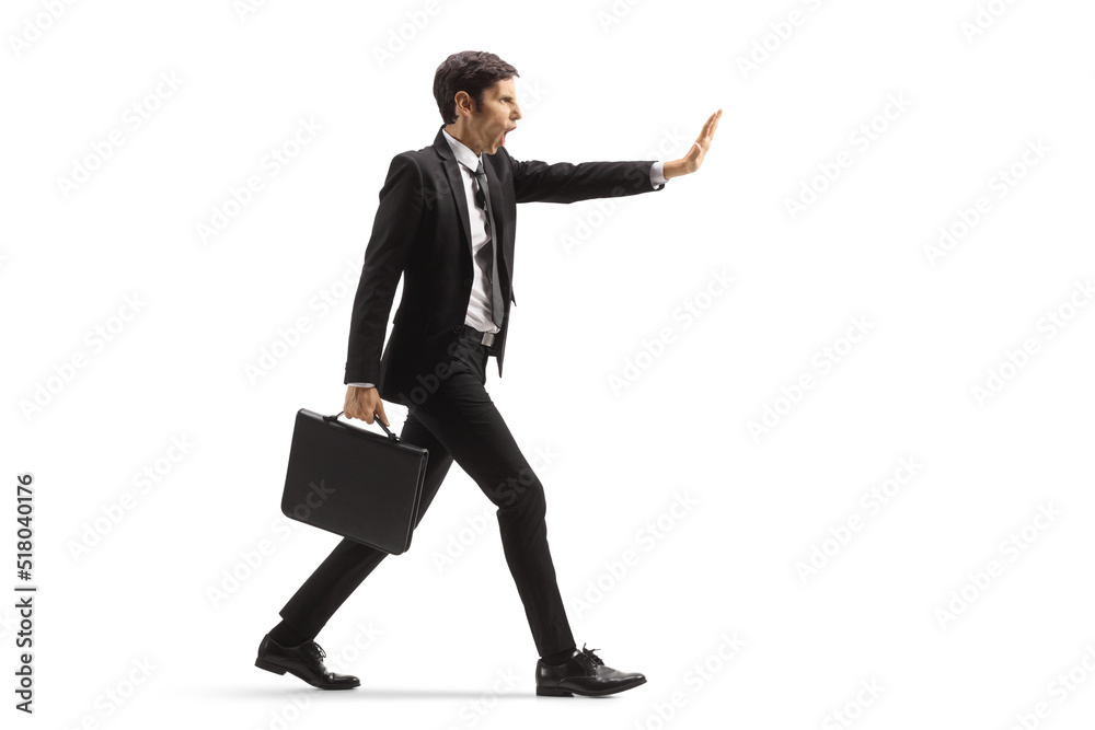 Full length profile shot of an angry businessman walking and gesturing stop Full length profile shot of an angry businessman walking and gesturing stop