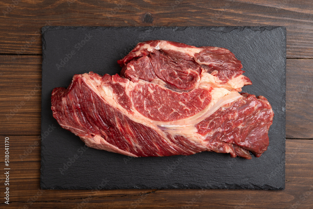 Raw beef steak on wooden table top. Healthy food concept. beef cut and spices for cooking bbq sauce Raw beef steak on wooden table top. Healthy food concept. beef cut and spices for cooking bbq sauce