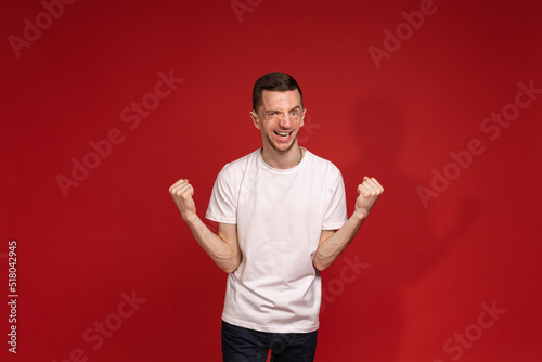 A young man in a white T-shirt with tricher syndrome rejoices
