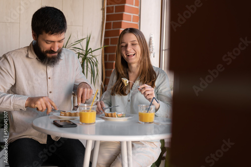 Happy young couple enjoying their breakfast together